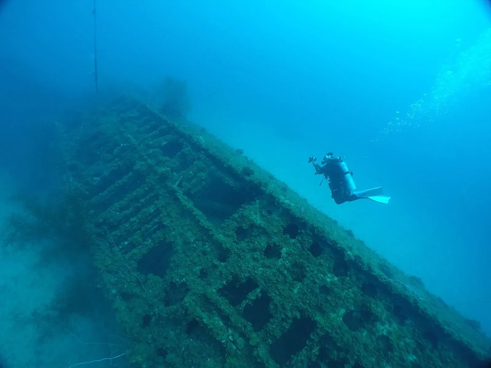A diver swimming alongside the hull of the Japanese submarine I-169 in Chuuk Lagoon