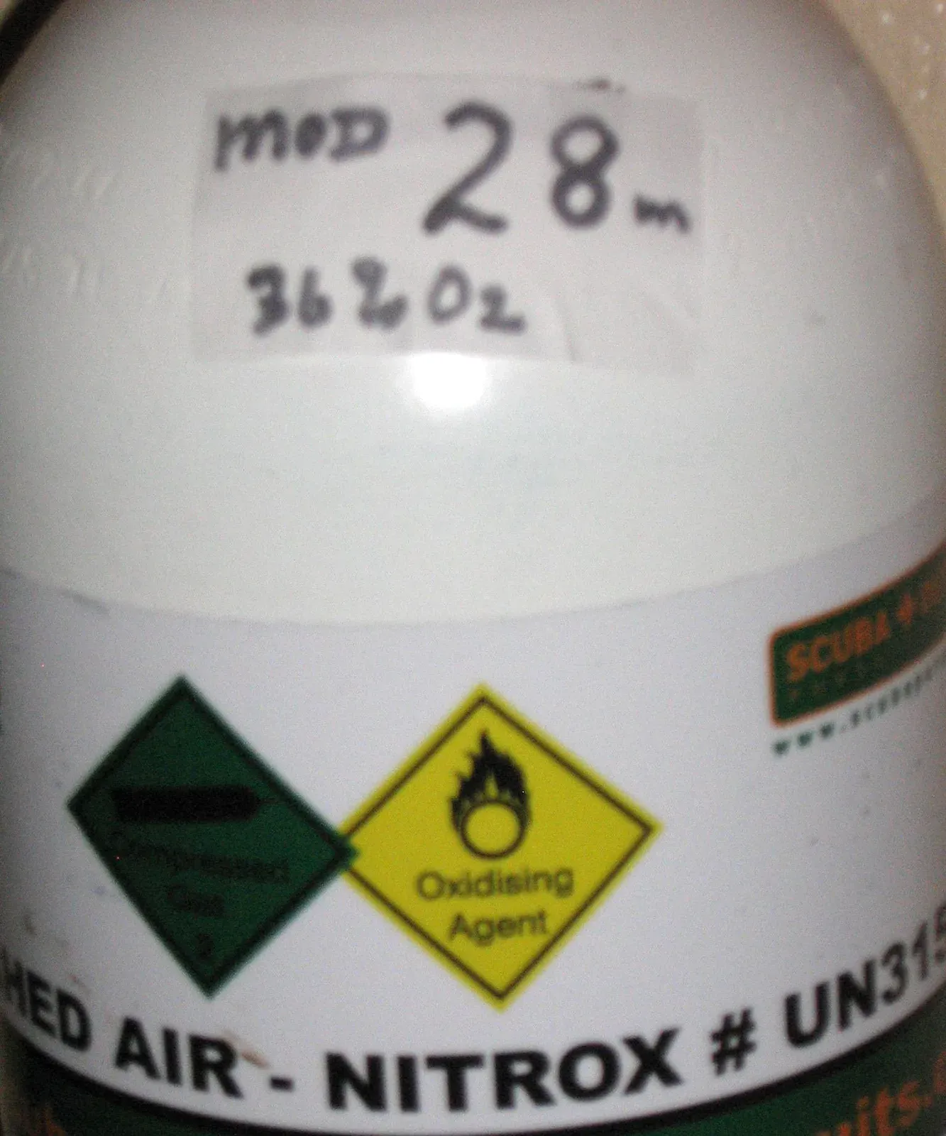A nitrox cylinder neck marked by hand with MOD 28 m and 36 percent oxygen above an enriched air label