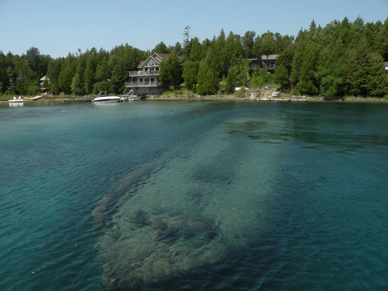 The hull of the schooner Sweepstakes visible through clear green water in Big Tub Harbour, Tobermory